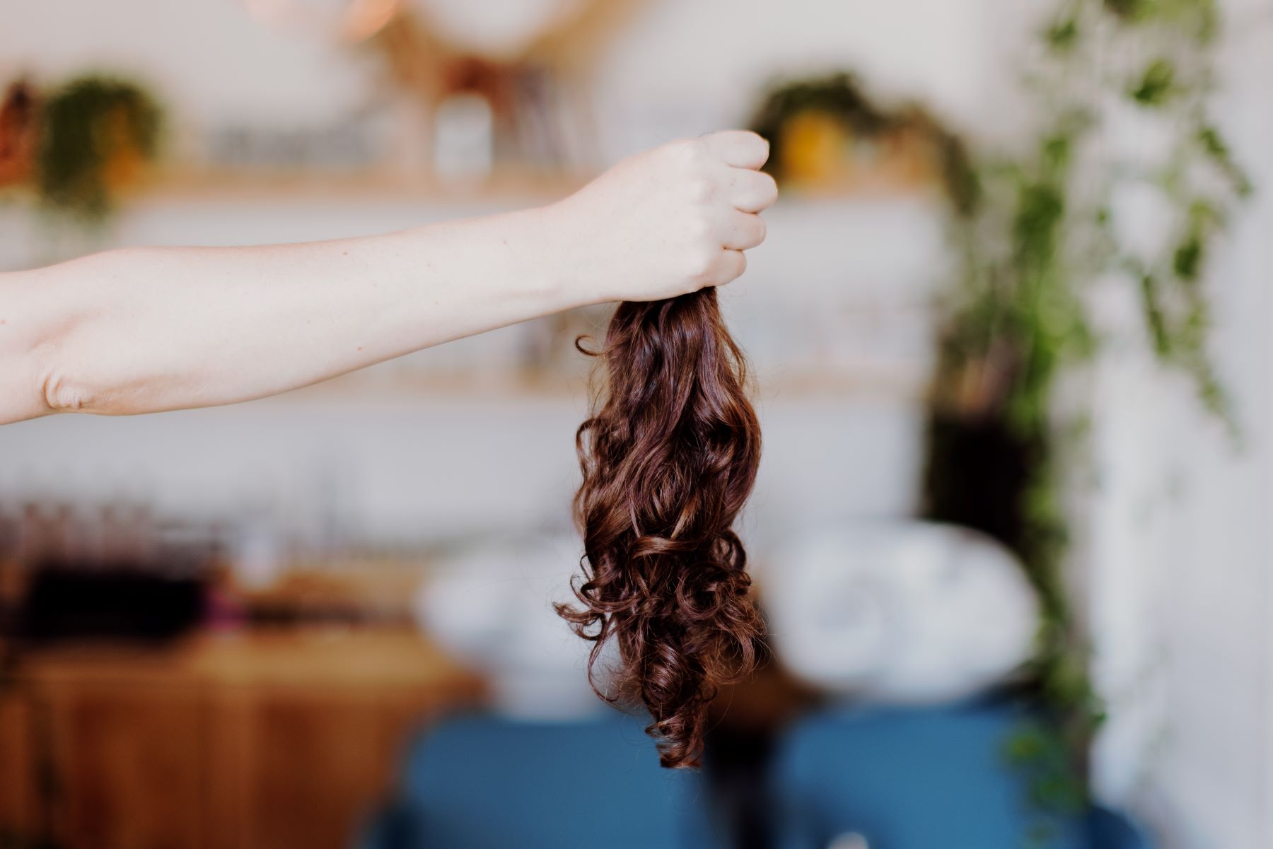 Mily Cuts tenant une mèche de cheveux prête à être à une association pour un don de cheveux